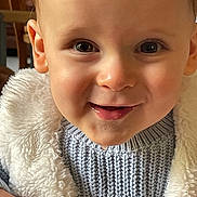 Gaël participe au concours pour gagner de l'argent avec cette photo : toddler, child, face, smile, eyes, sweater, knitwear, jacket, fur, warm_clothing, cute, indoors, portrait, happy, baby, skin, cheeks, person, closeup, infant