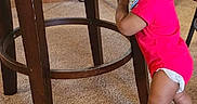 Karter joined the competition — help win amazing prizes! baby, barefoot, candid, carpet, cheeky, child, cute, face, floor, furniture, home, indoor, infant, onesie, person, red_clothing, smiling, standing, wooden_chair, young_child