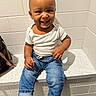 toddler, child, smiling, white_shirt, blue_jeans, socks, sitting, countertop, tile_wall, indoor, happy, person, cute, baby, portrait, casual_clothing, bag, hand, footwear, face