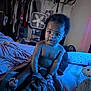 baby, child, bed, blanket, blue_light, clothing, fan, furniture, indoor, person, portrait, room, sitting, toy, toddler, wall, window_curtain, fuzzy_blanket, face, hair