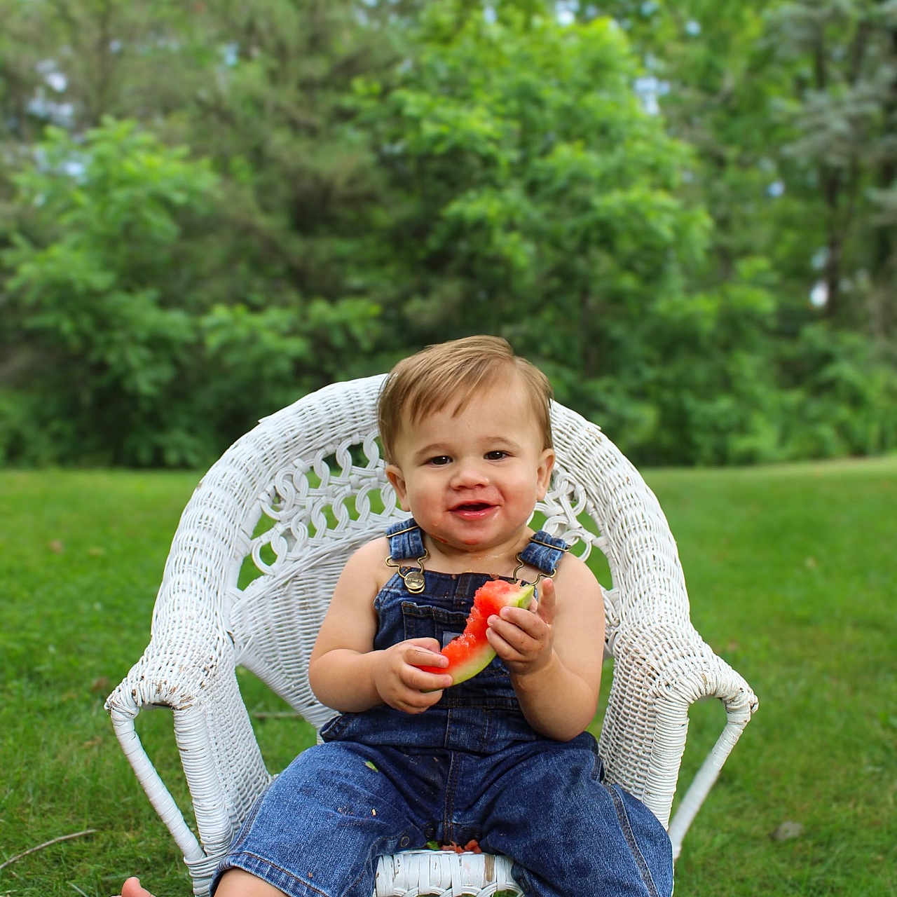 Bennett is registered to the contest to win money with this photo: baby, clothing, face, food, fruit, grass, head, melon, nature, outdoors, pants, park, person, photography, plant, portrait, produce, summer, tree, vegetation