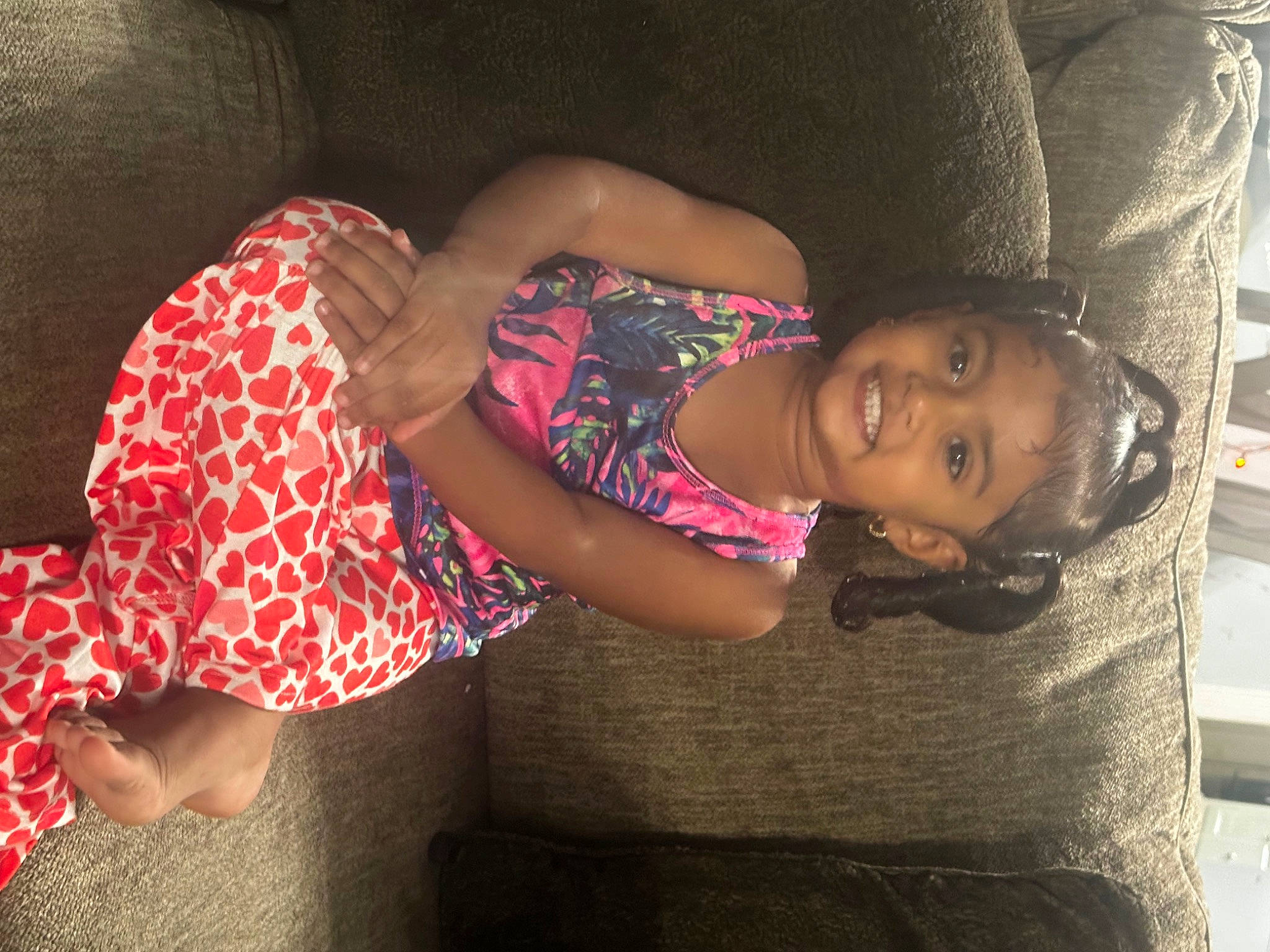 Armani is registered to the contest to win money with this photo: arm, black_hair, child, comfort, dress, elbow, finger, fun, human_body, joint, joy, leg, lip, mammal, mouth, person, pink, skin, textile, thigh