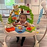 Nylah joined the competition — help win amazing prizes! baby, child, activity_jumper, toys, giraffe_toy, indoor, floor, window, door, hospital_room, curious, playful, colorful, infant, flooring, plastic_toys, seat, legs, person, young_child