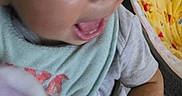 Nylah is registered to the contest to win money with this photo: baby, child, face, hand, toy, clothing, bib, indoor, expression, smile, skin, arm, fabric, soft_toy, closeup, infant, person, cute, happy, blurred