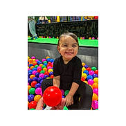 Alana joined the competition — help win amazing prizes! child, toddler, ball_pit, colorful_balls, smiling, black_clothing, indoor, play, happy, person, toy, reaching, sitting, fun, bright_colors, young_child, entertainment, cute, joy, leisure