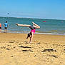 Justine a rejoint le concours — aidez-le/la à gagner de superbes lots ! child, beach, handstand, sand, ocean, water, sky, boats, people, summer, shore, vacation, outdoor, sunny, waves, casual_clothing, active, fun, holiday, shoreline