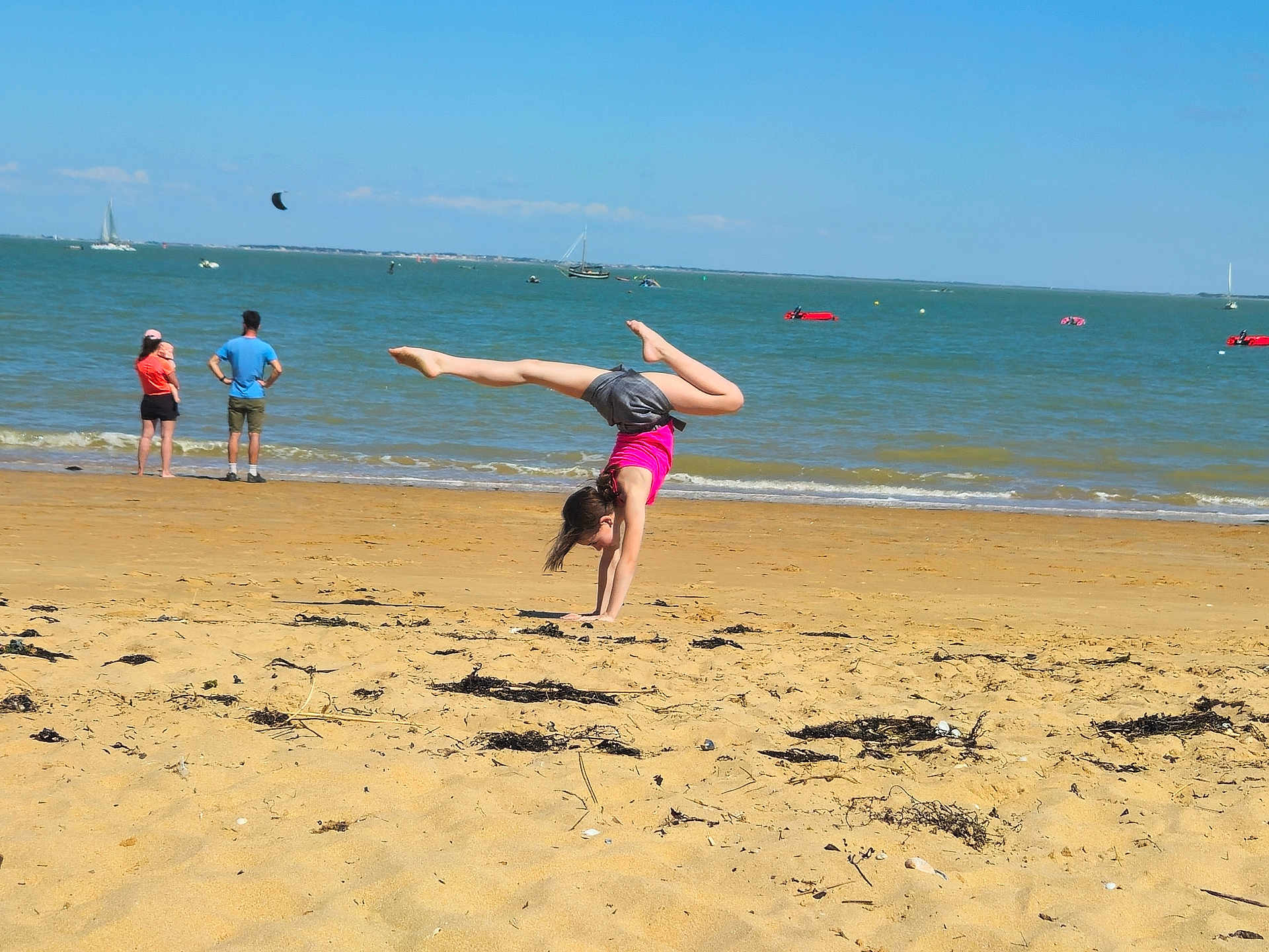 Justine a rejoint le concours — aidez-le/la à gagner de superbes lots ! child, beach, handstand, sand, ocean, water, sky, boats, people, summer, shore, vacation, outdoor, sunny, waves, casual_clothing, active, fun, holiday, shoreline