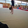 activity, athlete, balance, child, exercise, fitness, floor, gymnasium, gymnast, gymnastics, handstand, indoor, person, pose, practice, sport_equipment, sports, stretch, training, young
