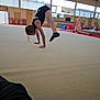 Justine a rejoint le concours — aidez-le/la à gagner de superbes lots ! athlete, balance, black_leotard, child, exercise, gym_equipment, gym_floor, gymnasium, gymnast, handstand, indoors, physical_activity, pose, practice, socks, sport, strength, training, windows, young