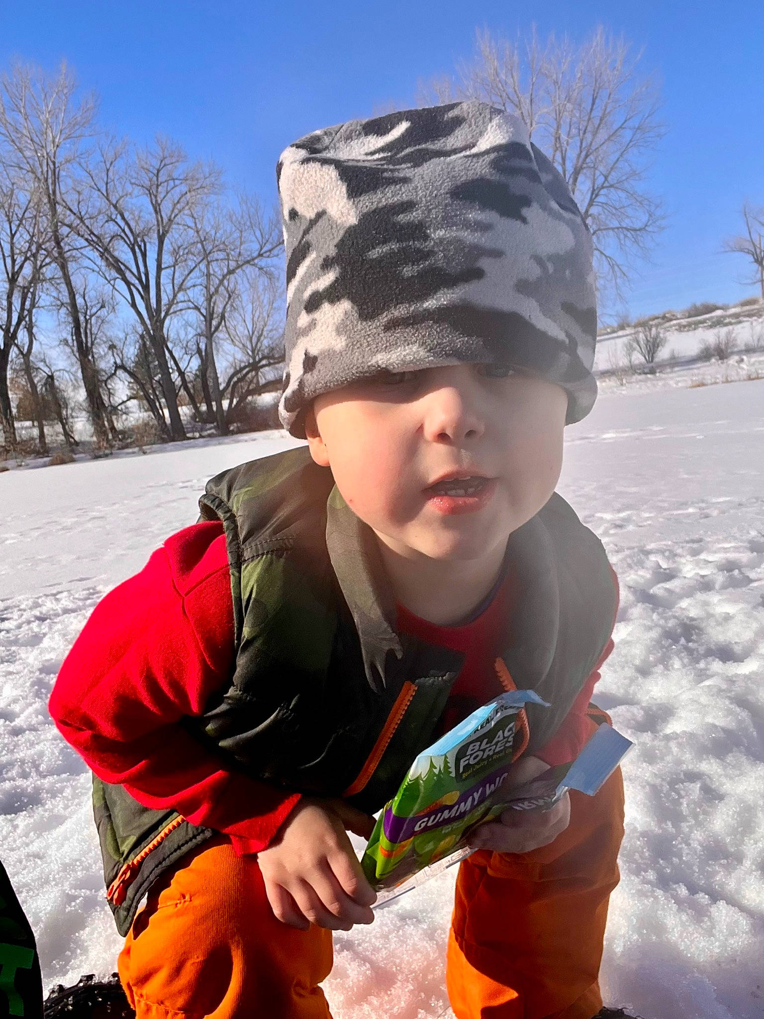 Corbin is registered to the contest to win money with this photo: beanie, cap, child, fashion_accessory, freezing, fun, glove, grass, happy, headwear, knit_cap, people_in_nature, person, personal_protective_equipment, play, recreation, sitting, sky, snow, toddler