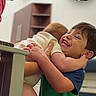 Charlotte is registered to the contest to win money with this photo: child, baby, hug, smile, indoor, family, person, green_shirt, short_hair, happy, interaction, love, affection, adult, furniture, cabinet, floor, home, joy, toddler