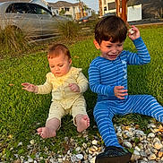 Charlotte is registered to the contest to win money with this photo: child, children, baby, toddler, pajamas, grass, rocks, outdoor, play, smiling, happy, sunlight, daylight, tree, car, house, nature, footwear, sitting, fun