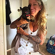 Slash is registered to the contest to win money with this photo: bag, blonde_hair, casual, clothing, dog, door, floor, furniture, hand, holding, home, indoor, pet, portrait, puppy, red_collar, smiling, tattoo, white_dress, woman
