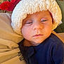 baby, infant, santa_hat, blue_clothing, sleepy, closeup, face, child, person, cozy, holiday, cute, indoors, soft_texture, warm, young, headwear, portrait, resting, newborn