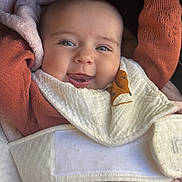 Charlyne a rejoint le concours — aidez-le/la à gagner de superbes lots ! baby, smiling, face, hand, blanket, sweater, cozy, infant, portrait, cute, warm, child, happy, clothing, raising_hand, closeup, soft, texture, indoors, expression