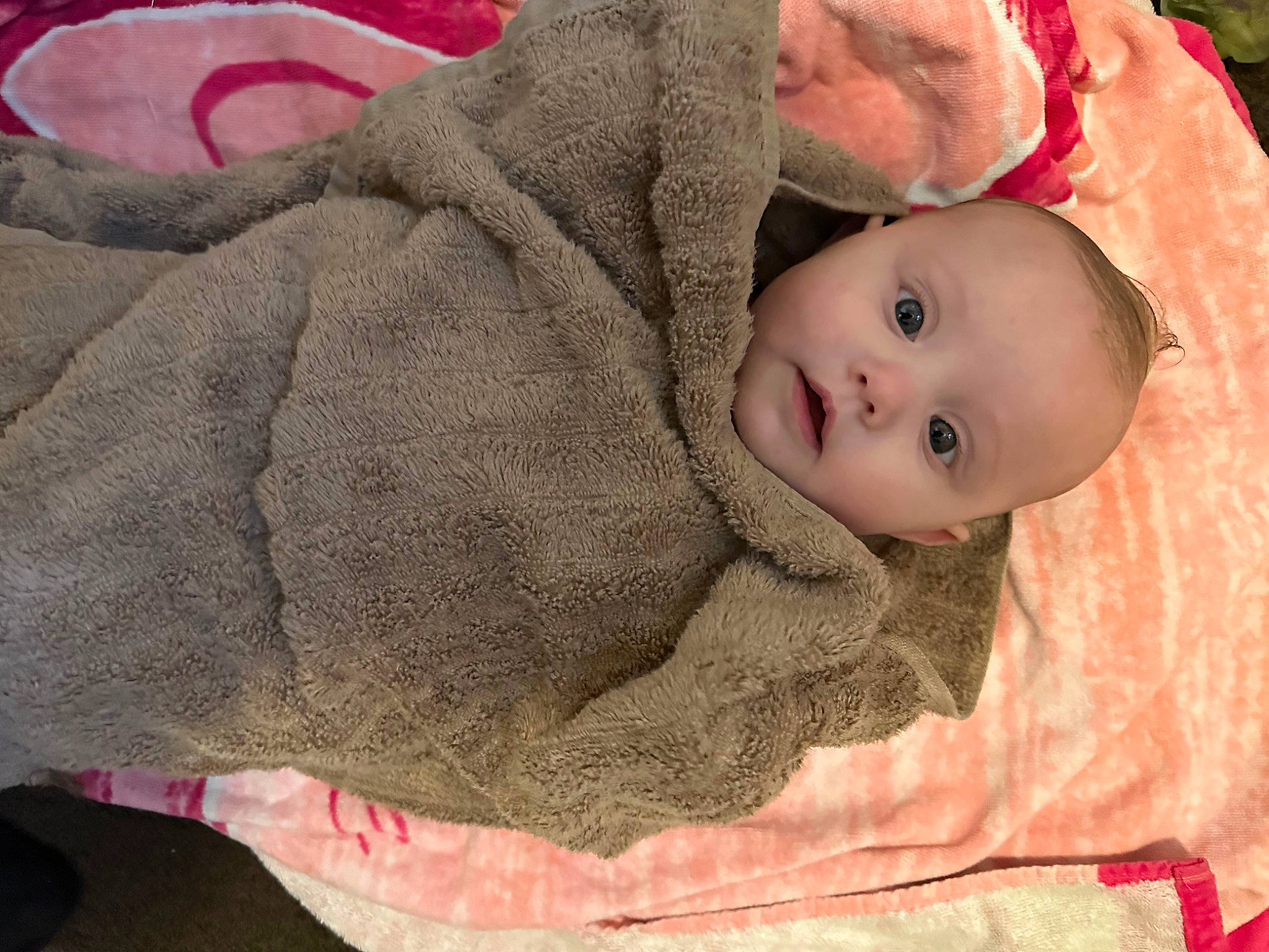 Lilly is registered to the contest to win money with this photo: baby, baby_products, baby_toddler_clothing, cheek, child, comfort, flooring, fur, knit_cap, linens, nose, pattern, person, sitting, skin, sleeve, toddler, wood, wool, woolen
