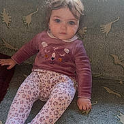 Candice participe au concours pour gagner de l'argent avec cette photo : toddler, child, sitting, couch, dinosaur_pattern, sweater, leggings, animal_face, indoor, curly_hair, blue_eyes, cozy, soft_lighting, patterned_fabric, young_child, casual_clothing, portrait, looking_at_camera, home_interior, cute
