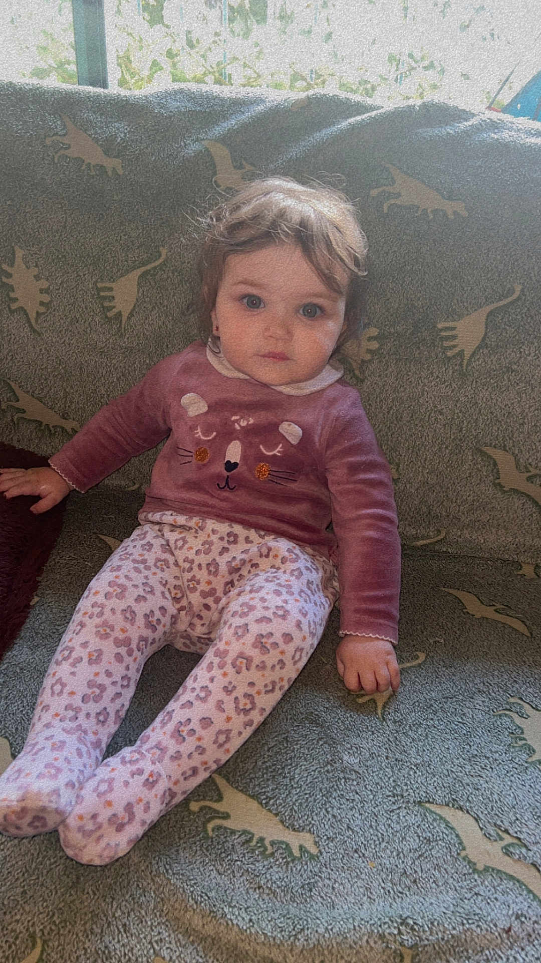 Candice participe au concours pour gagner de l'argent avec cette photo : toddler, child, sitting, couch, dinosaur_pattern, sweater, leggings, animal_face, indoor, curly_hair, blue_eyes, cozy, soft_lighting, patterned_fabric, young_child, casual_clothing, portrait, looking_at_camera, home_interior, cute