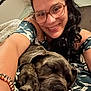 Aïko participe au concours pour gagner de l'argent avec cette photo : woman, dog, sleeping, glasses, smiling, indoor, cuddling, closeup, portrait, curly_hair, bracelet, patterned_dress, relaxed, happy, pet, friendship, cozy, comfort, resting, home