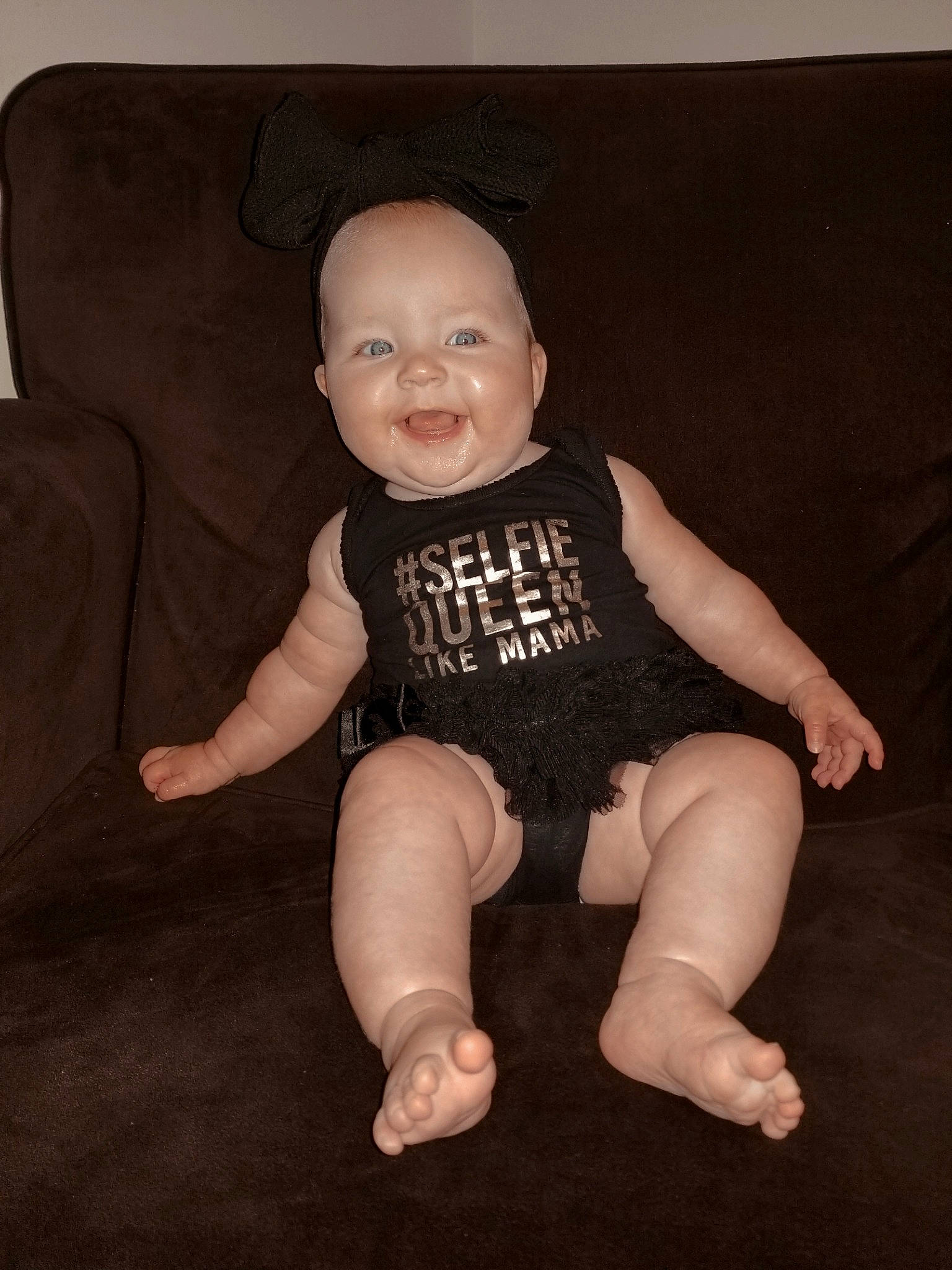 Scarlett is registered to the contest to win money with this photo: baby, baby_toddler_clothing, cheek, chin, comfort, couch, eye, finger, flash_photography, head, human_body, iris, knee, leg, neck, person, skin, sleeve, smile, t_shirt