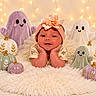 baby, infant, child, portrait, smiling, headband, flower, ghost_plushies, pumpkins, halloween, fairy_lights, festive, cozy, blanket, faux_fur, indoor, nursery, sitting, face, photography