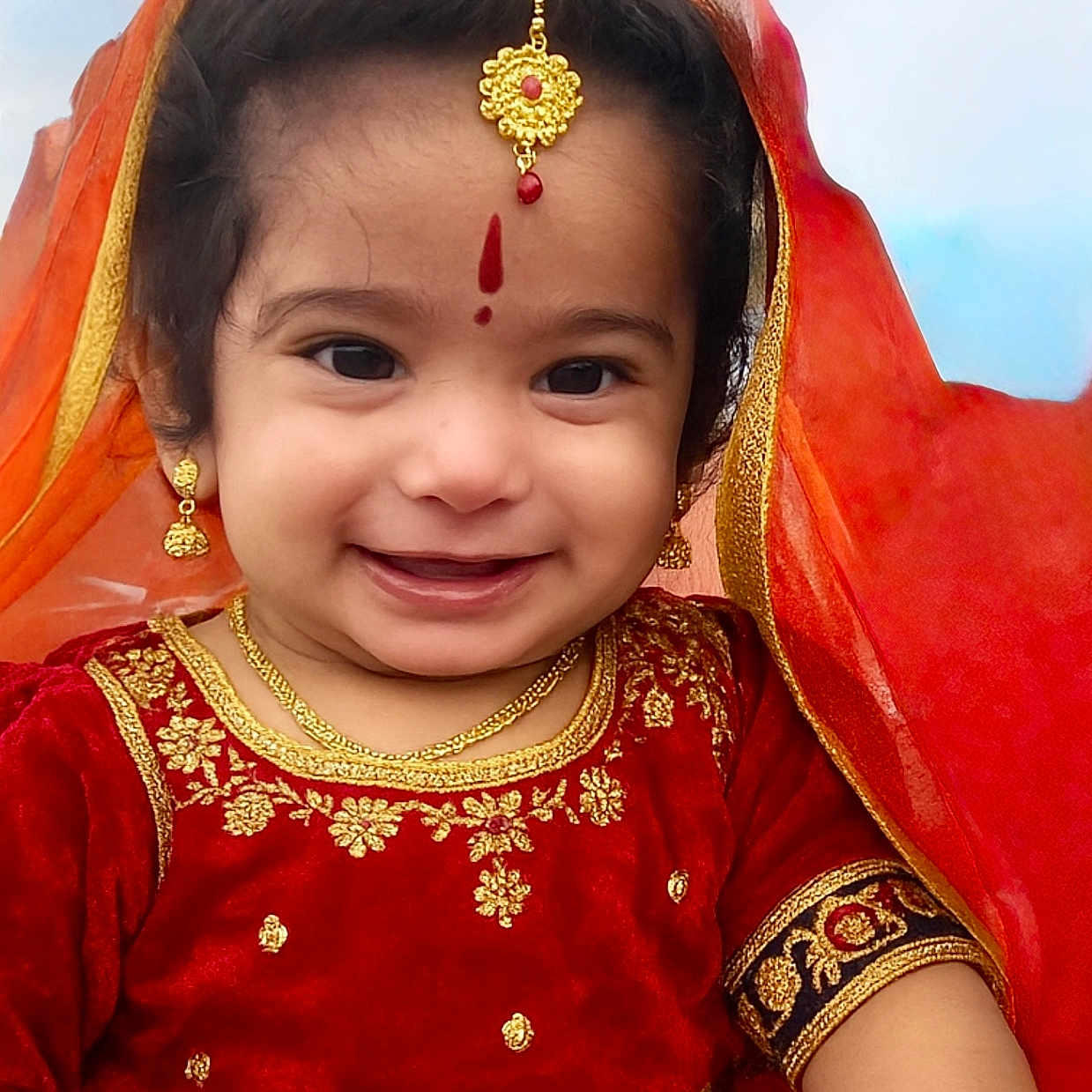 Viha is registered to the contest to win money with this photo: bracelet, celebration, child, cultural, cute, earrings, face, festival, gold_jewelry, happy, headpiece, necklace, outdoor, portrait, red_dress, smiling, toddler, traditional_clothing, veil, young