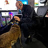 Delilah joined the competition — help win amazing prizes! black_clothing, cable, casual, chair, collar, computer, desk, dog, floor, headset, indoor, interaction, man, monitor, office, petting, screen, technology, wearing_glasses, workspace