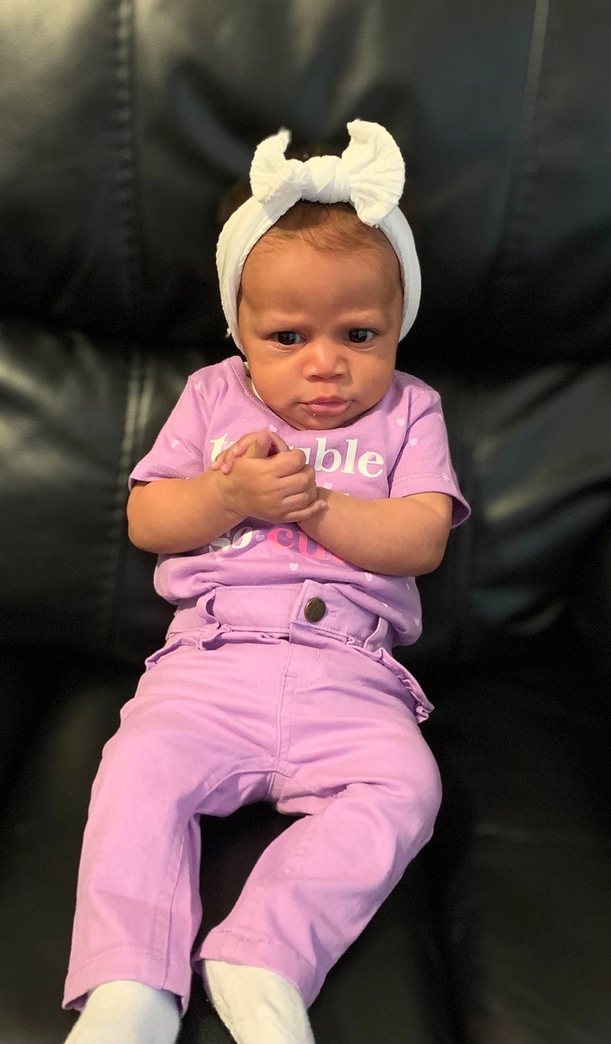 Mahogany is registered to the contest to win money with this photo: abdomen, baby, baby_toddler_clothing, cheek, event, face, fun, gesture, happy, human_body, lip, magenta, person, pink, purple, sitting, skin, sleeve, thigh, thumb
