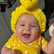 Elliana joined the competition — help win amazing prizes! baby, infant, yellow_clothing, headband, smiling, happy, cute, indoors, face, child, apparel, textile, headwear, one_person, lying_down, closeup, skin, expression, joy, playful