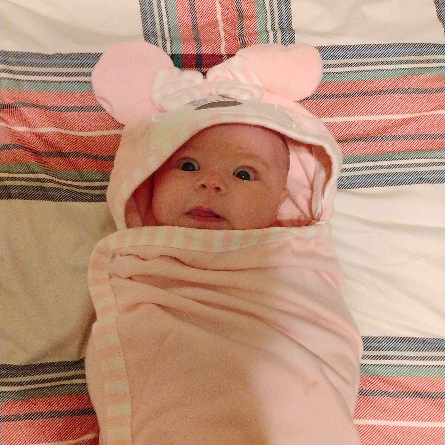 Dianne joined the competition — help win amazing prizes! baby, bedspread, child, comfortable, curious, cute, hood, indoors, infant, lying_down, mouse_ears, person, pink_blanket, portrait, soft, striped, surprised, tongue, wide_eyes, wrapped
