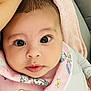 baby, infant, close_up, face, eyes, pink_bib, cartoon_characters, blanket, cute, adorable, child, young, portrait, cozy, soft_texture, clothing, person, expression, indoors, skin