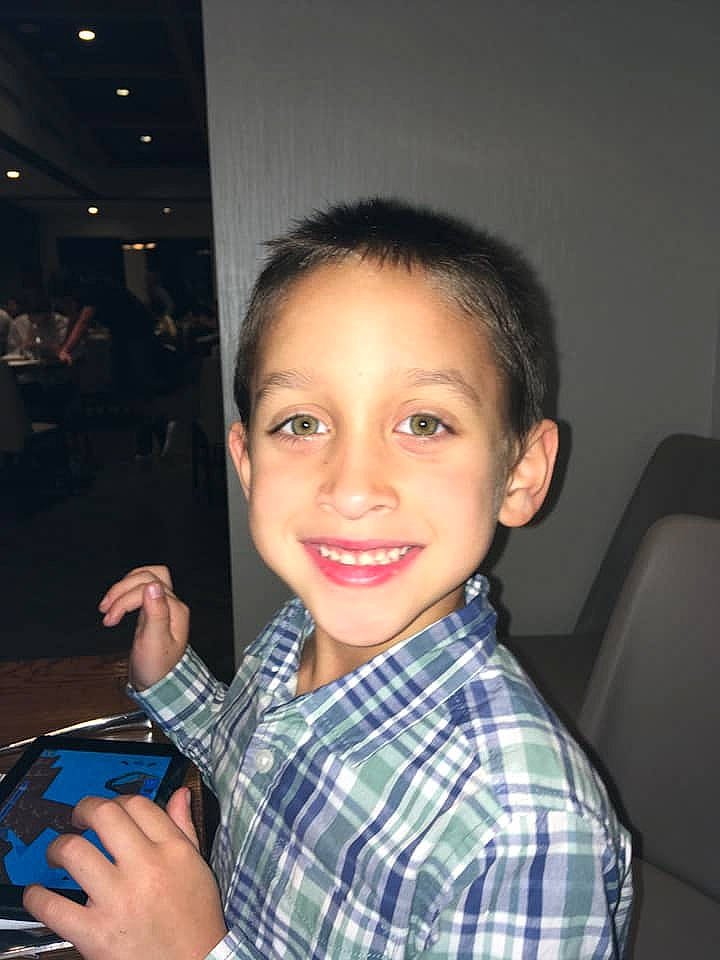 Grayson is registered to the contest to win money with this photo: child, design, gesture, joy, pattern, person, plaid, smile, thumb