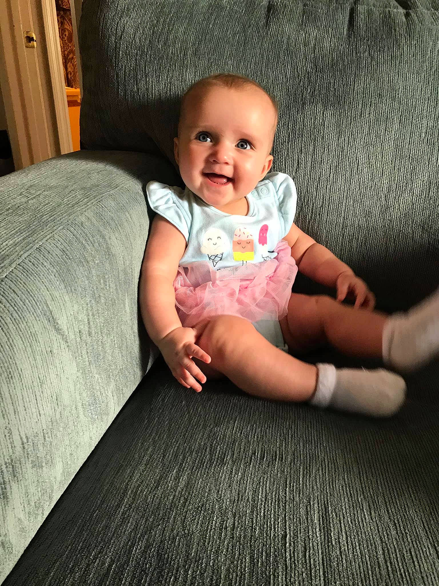 Mariella is registered to the contest to win money with this photo: arm, baby, cheek, child, comfort, face, finger, floor, flooring, hand, head, leg, person, pink, play, sitting, skin, smile, toddler, wood