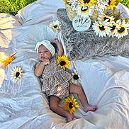 Zaryus is registered to the contest to win money with this photo: baby, infant, headband, blanket, sunflower, flower, basket, outdoor, grass, one_month, cute, patterned_clothing, lying_down, head, skin, feet, nature, celebration, soft_texture, milestone