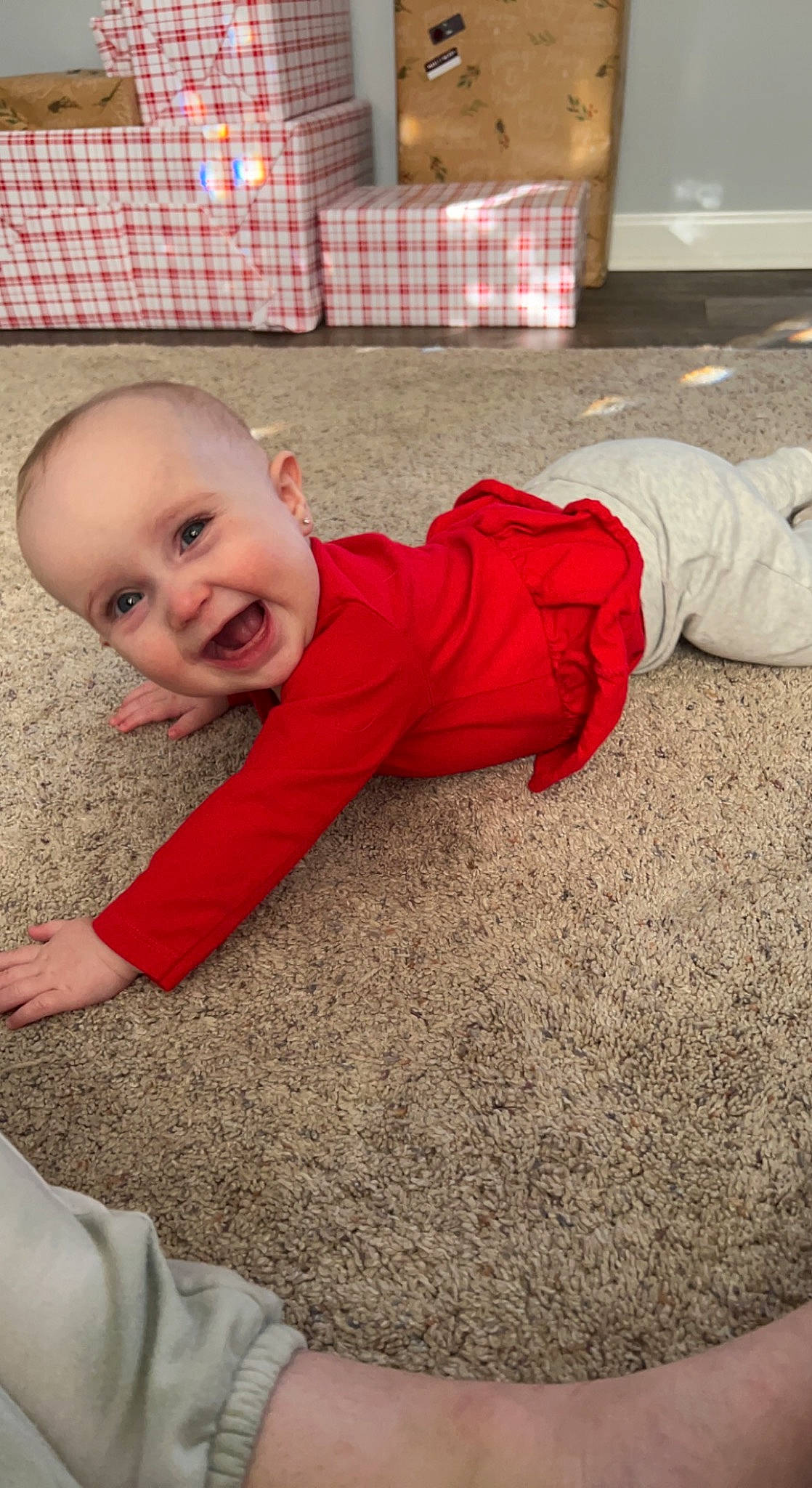 Addison is registered to the contest to win money with this photo: baby, baby_toddler_clothing, carpet, comfort, crawling, floor, flooring, fun, grass, happy, hardwood, head, human_body, human_leg, leg, pattern, person, sitting, smile, toddler
