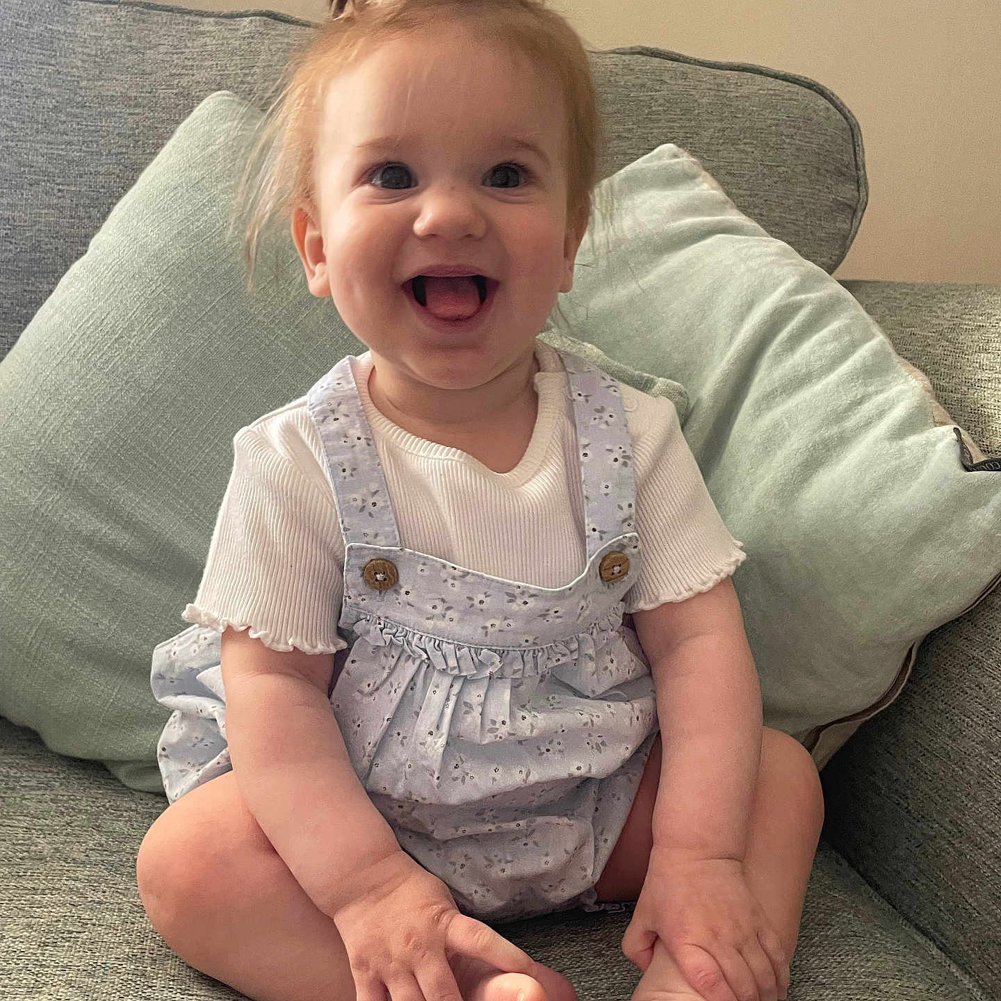 Olivia is registered to the contest to win money with this photo: architecture, baby, babylaughing, building, clothing, couch, cushion, face, furniture, happy, head, homedecor, jeans, laughing, pants, person, photography, portrait, sitting, smile