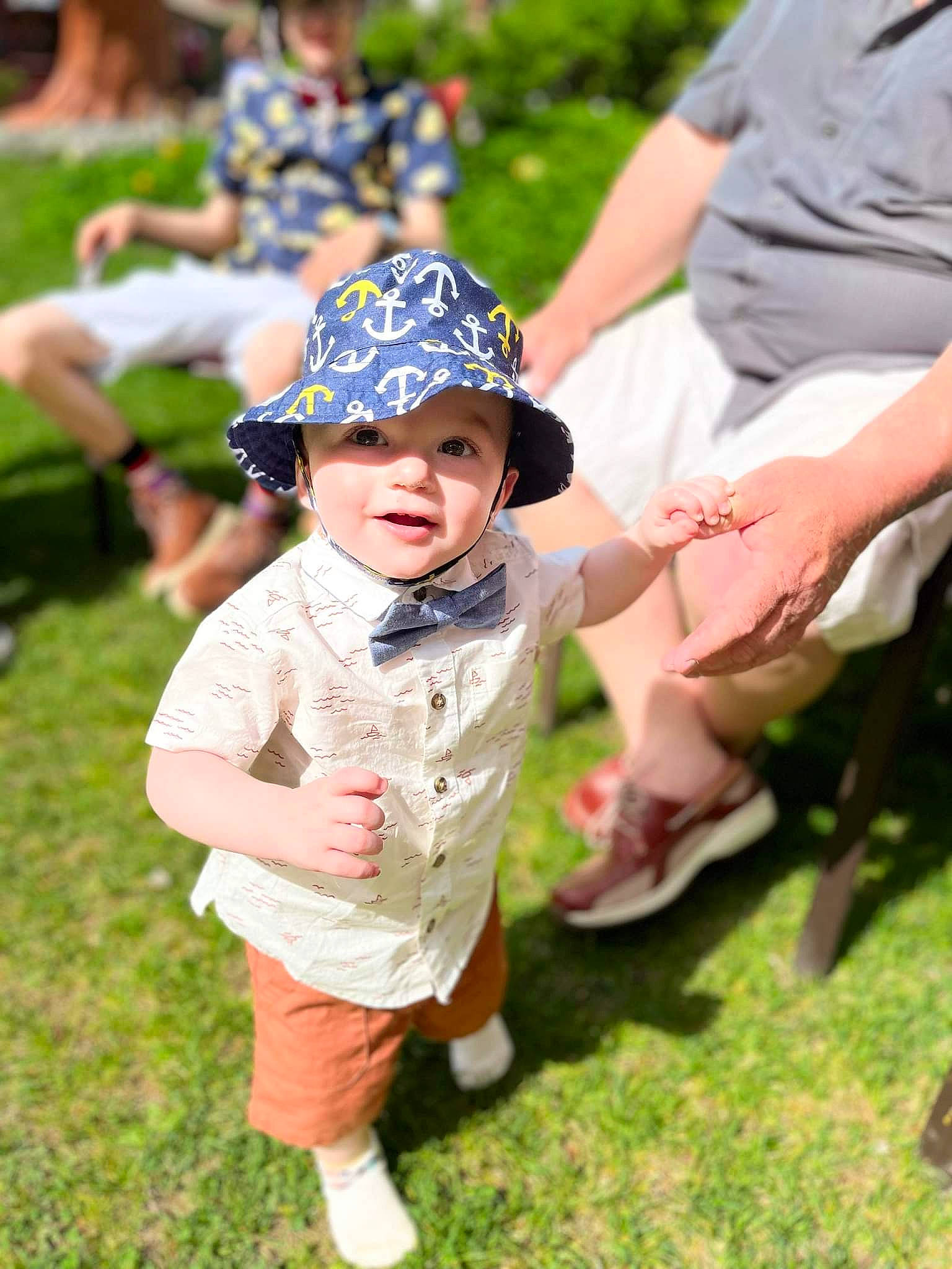 Everest is registered to the contest to win money with this photo: cap, clothing, event, face, fun, gesture, grass, grass_family, happy, hat, headwear, lawn, leisure, people_in_nature, person, plant, recreation, shorts, sun_hat, sunglasses