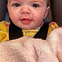 baby, child, face, eyes, smile, blanket, car_seat, clothing, yellow, pink, close_up, infant, cute, warm, portrait, young, soft_texture, happy, indoors, seatbelt