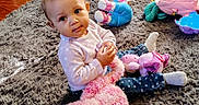 Ny'Ari is registered to the contest to win money with this photo: baby, child, infant, portrait, sitting, indoors, rug, plush_toy, stuffed_animal, doll, pink, blue, polka_dot, clothing, smiling, curious, playroom, toy, floor, cozy