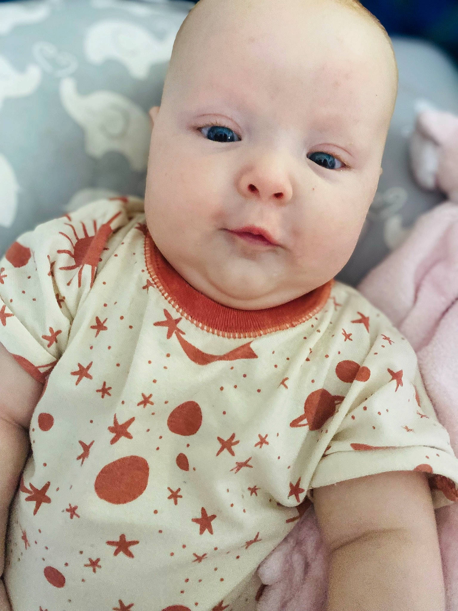 Santana is registered to the contest to win money with this photo: baby, baby_toddler_clothing, cheek, child, chin, collar, eyelash, happy, iris, lip, mouth, neck, nose, pattern, person, pink, sitting, skin, sleeve, toddler