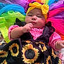 baby, infant, child, headband, bow, sunflower_dress, colorful_clothing, tulle, rainbow_colors, plush_toys, soft_toys, indoors, portrait, cute, chubby_cheeks, hand, fabric, smiling, cozy, bright_colors