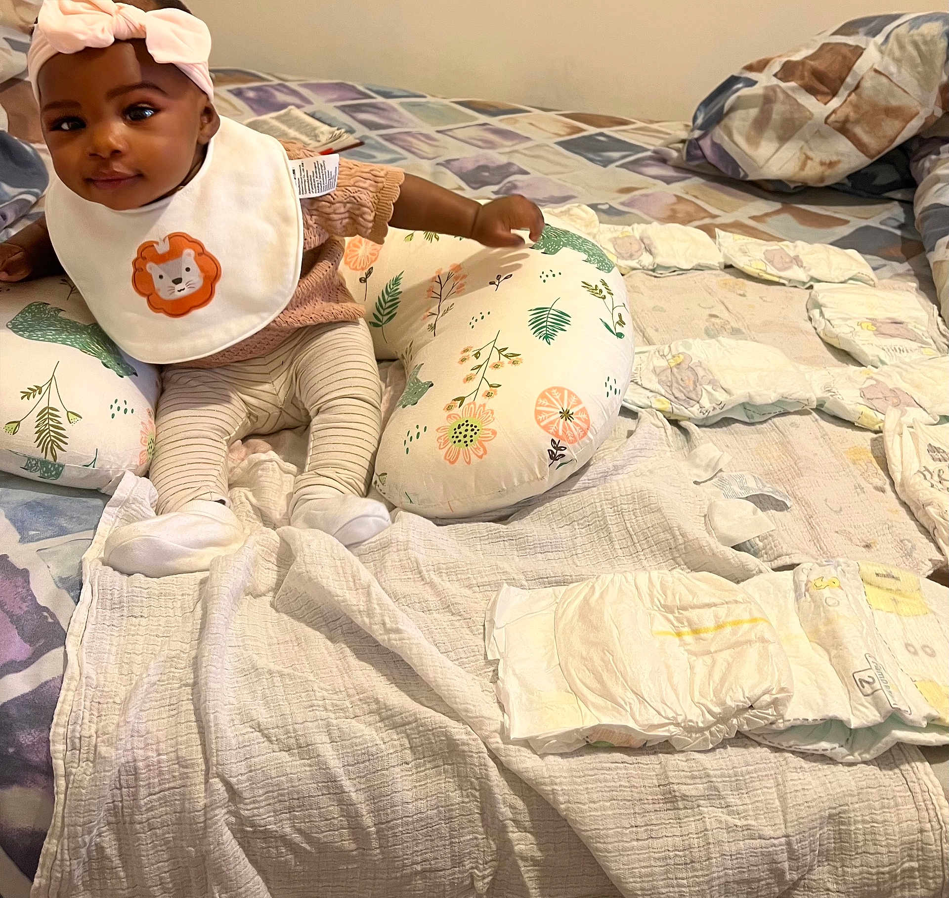 Najibat joined the competition — help win amazing prizes! baby, child, infant, bow, bib, lion, pillow, diapers, bed, blanket, striped_pants, socks, smile, indoor, cute, young_child, cloth, fabric, person, resting