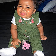 Sernity joined the competition — help win amazing prizes! baby, child, smiling, sitting, pink_bow, green_outfit, white_socks, pacifier, indoors, bed, dark_background, cute, happy, portrait, infant, young_child, person, fashion, accessory, home
