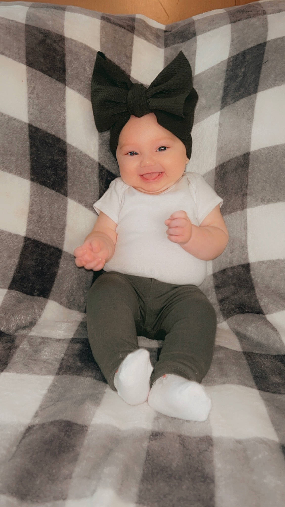 Arayah joined the competition — help win amazing prizes! baby, baby_toddler_clothing, beanie, child, comfort, costume_hat, foot, happy, headwear, human_leg, joy, knee, linens, pattern, person, plaid, sitting, sleeve, smile, sock