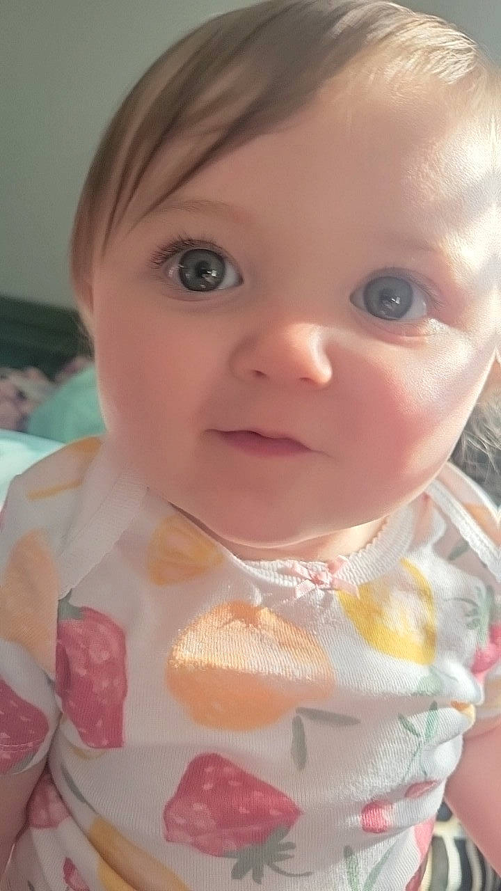 Kyrah is registered to the contest to win money with this photo: baby, baby_toddler_clothing, blond, cheek, child, chin, dress, ear, eyelash, facial_expression, hairstyle, iris, lip, mouth, nose, person, pink, skin, sleeve, sweetness