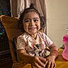 toddler, child, smiling, high_chair, wooden_chair, pink_shirt, cartoon_cow, messy_face, happy, indoor, curtains, table, bottle, young_child, portrait, person, cute, playful, baby_food, feeding_time