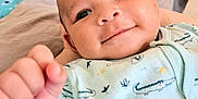 Ismaël participe au concours pour gagner de l'argent avec cette photo : baby, smiling, close_up, onesie, crocodile_print, hand, infant, cute, face, child, toy, colorful, blanket, soft, indoor, portrait, happy, young_child, clothing, expression