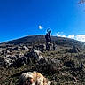 Rocco participe au concours pour gagner de l'argent avec cette photo : dog, outdoor, grass, rock, hill, sky, cloud, person, nature, sunlight, landscape, field, blue_sky, animal, pet, leisure, daytime, casual, scenic, playful