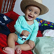 Adan joined the competition — help win amazing prizes! baby, child, smiling, hat, onesie, panda_print, bed, red_stripes, wooden_chair, indoor, happy, cute, infant, sitting, footwear_absent, home, toy, colorful_bedding, playful, portrait