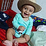 baby, child, smiling, hat, onesie, panda_print, bed, red_stripes, wooden_chair, indoor, happy, cute, infant, sitting, footwear_absent, home, toy, colorful_bedding, playful, portrait